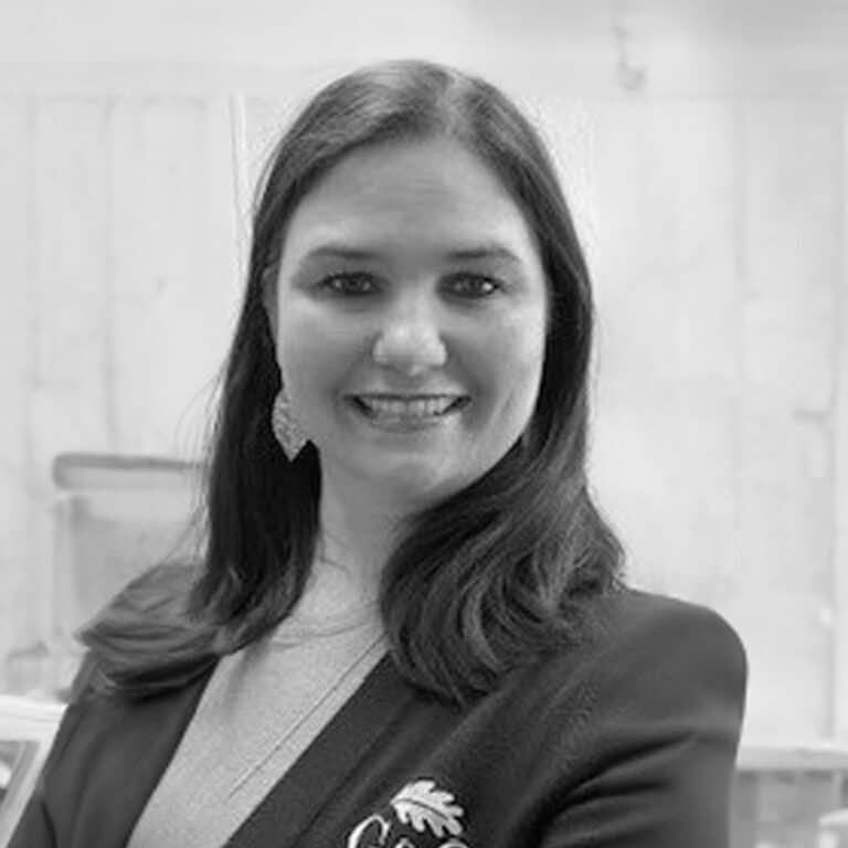 A black and white photo of a woman in a suit.