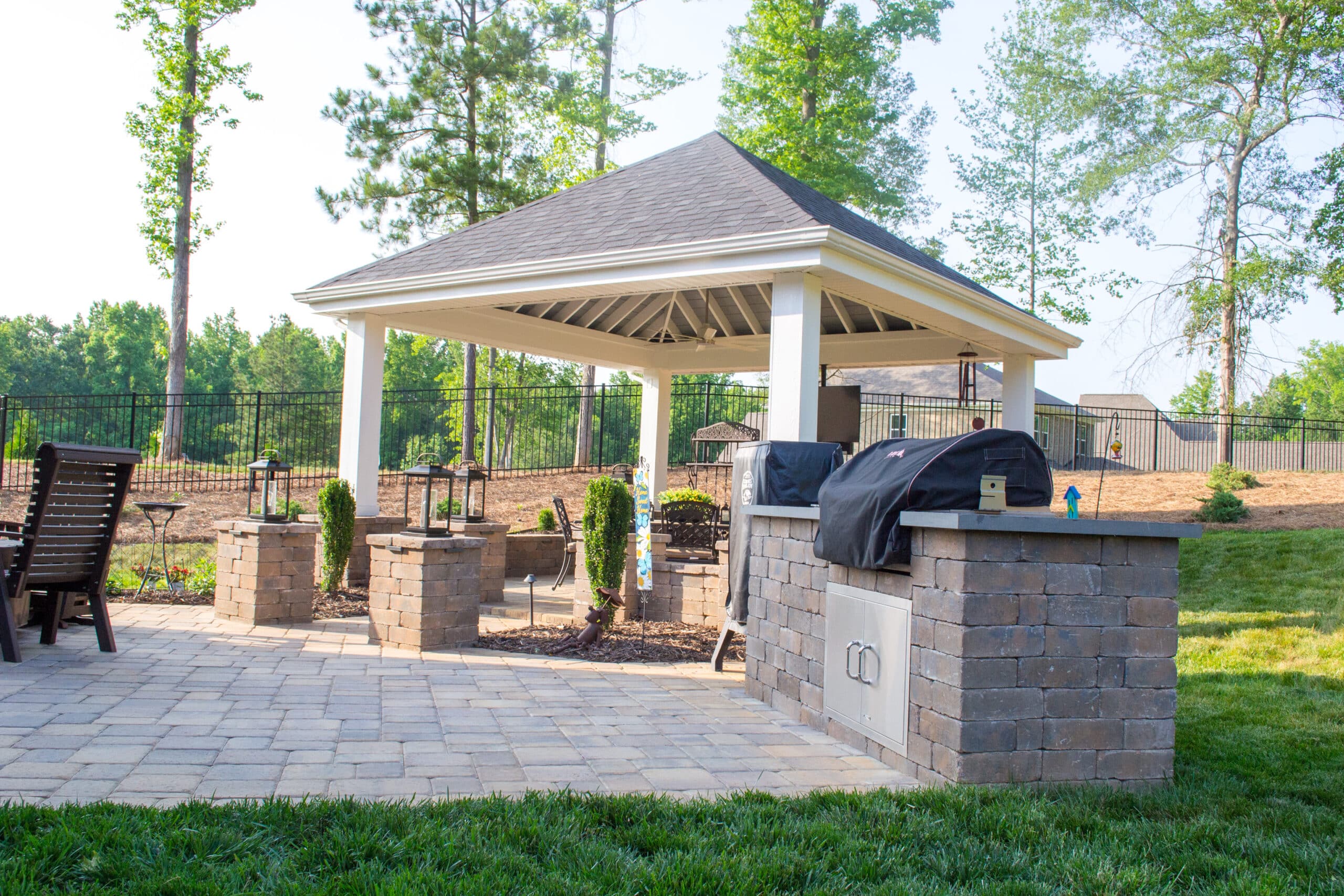A patio with a grill and gazebo.