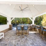 A brick patio with a grill and bar stools.