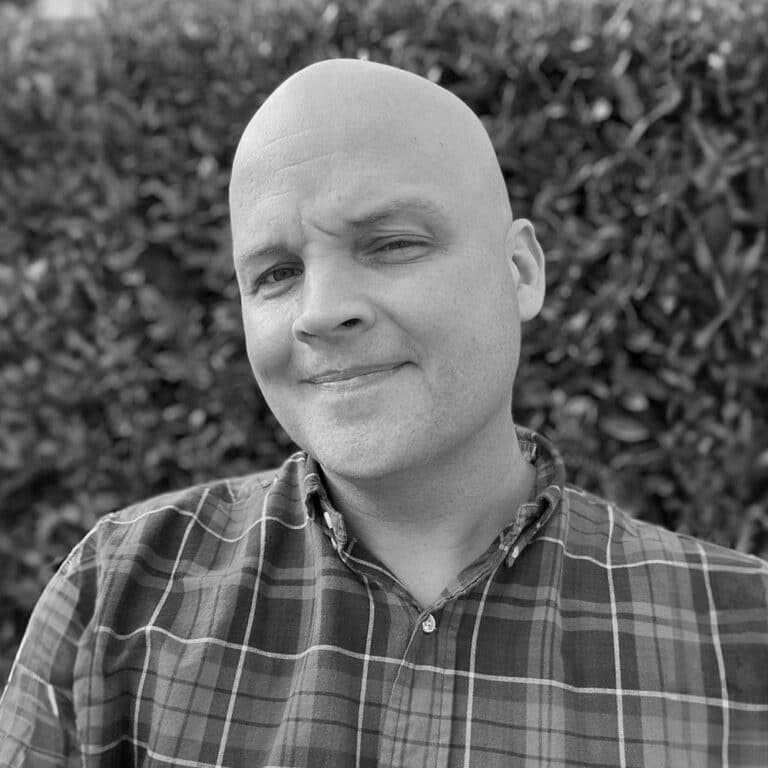 A black and white photo of a man with a bald head.