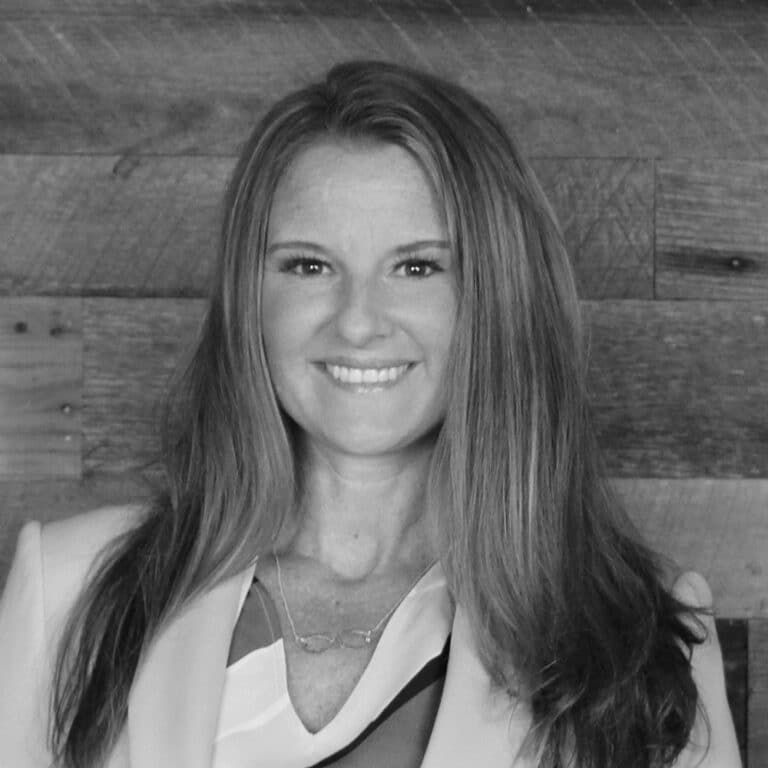 A black and white photo of a woman smiling.