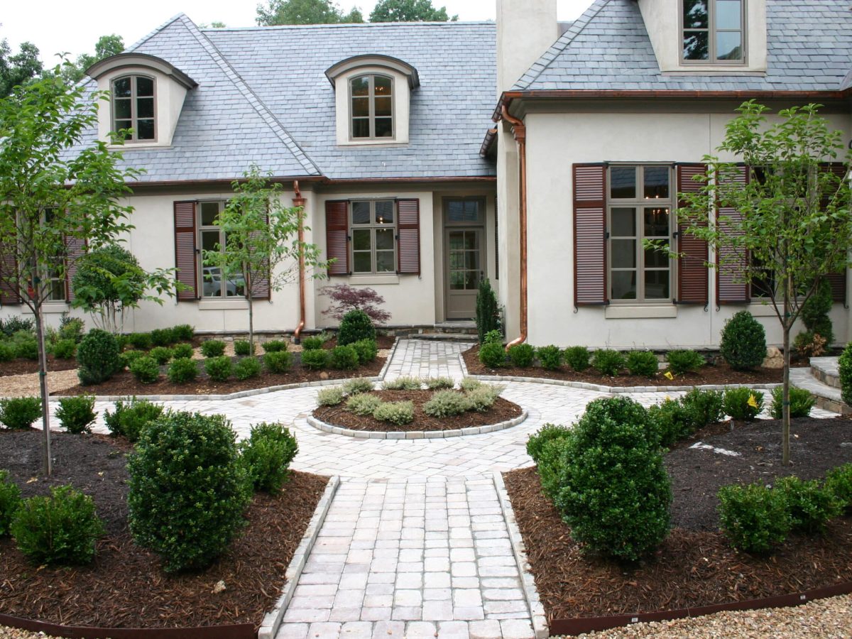 A house with a circular driveway and landscaping.